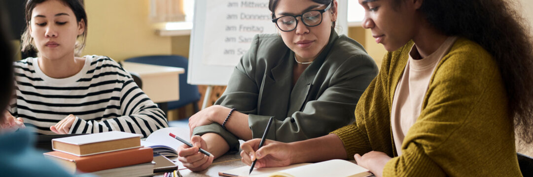 Teacher assisting students during a lesson at a desk