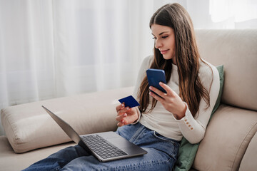 Woman at home doing online shopping on laptop with credit card