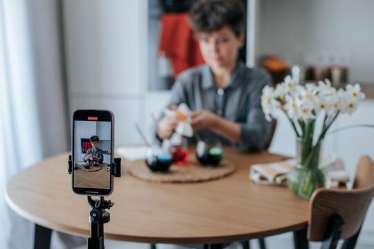 Woman recording an Easter egg decorating tutorial at home