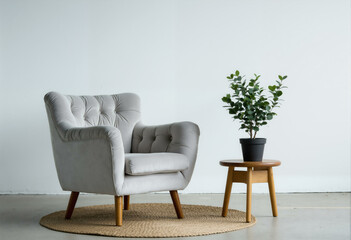 Fototapeta premium Grey armchair with coffee table and home plant. Minimalistic cozy living room interior with comfortable furniture, modern apartment decor