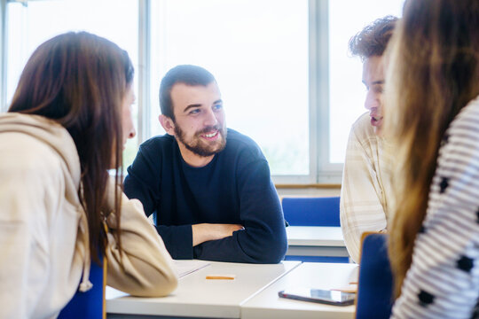 Students with different nationalities sit at their desks and discuss something