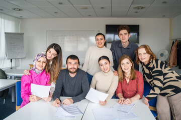 Group of students from different nationalities sitting at desks in a multicultural classroom setting