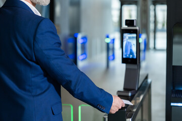 Close up picture of male hand with an access card on a security control
