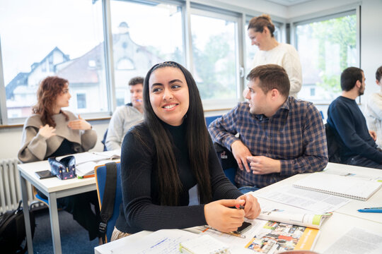 Smiling female student in a multicultural classroom during an international language course