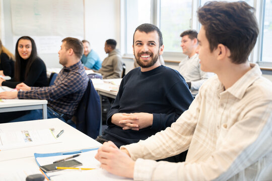 Students of diverse backgrounds communicating in a classroom setting - Powered by Adobe