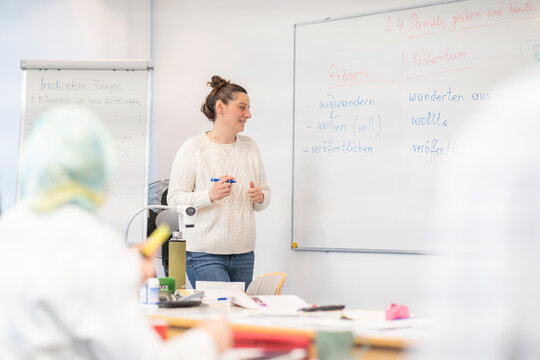 Teacher explaining grammar to adult students in a German language course