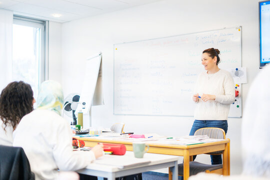 Teacher explaining to adult students in a multicultural German language class