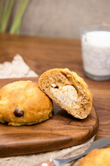 Whole wheat baked round bread on wooden table, warm tone atmosphere