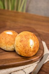 Whole wheat baked round bread on wooden table, warm tone atmosphere