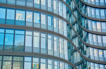 Modern curved high rise building. Glass facade of skyscraper. Office building exterior. Contemporary architectural design