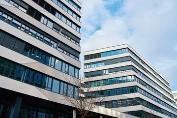 Obraz premium Modern office buildings with glass and concrete facades in city. Corporate offices in contemporary skyscrapers with reflective windows and geometric facades in modern cityscape