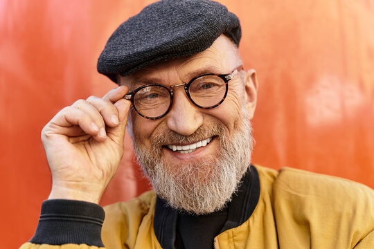 A chic older man showcases his fashion sense while walking through a bustling city.