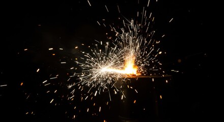 A burst of light and sparks emanates from a central point against a dark background