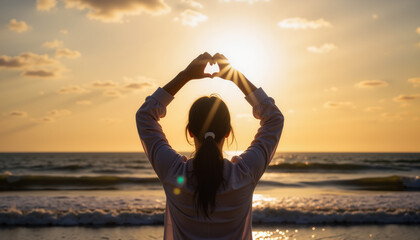 Fototapeta premium Woman expressing love at sunset on the beach 