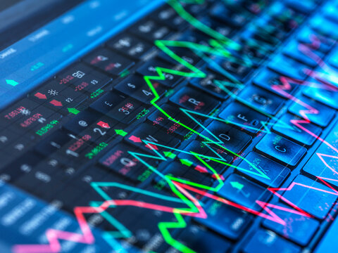 Colorful stock market graphs displayed on a computer keyboard representing financial data and analysis - Powered by Adobe