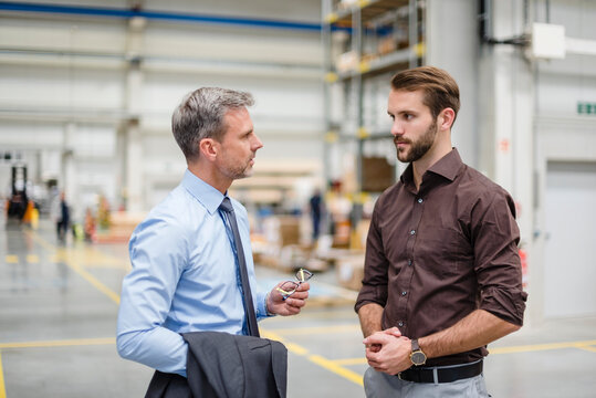 Two businessmen talking in a factory
