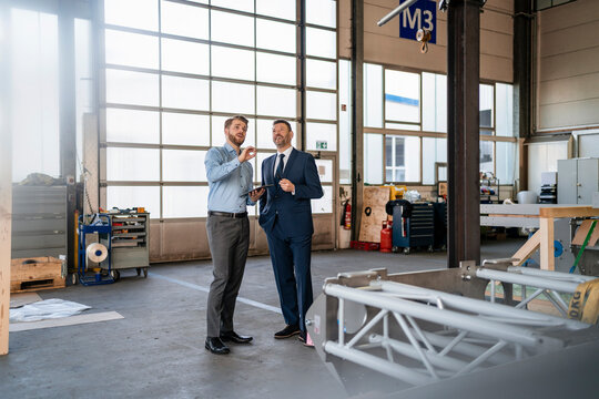 Two businessmen having a meeting in a factory