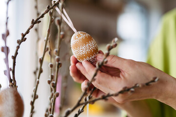 Decorating pussy willows branches with easter eggs.