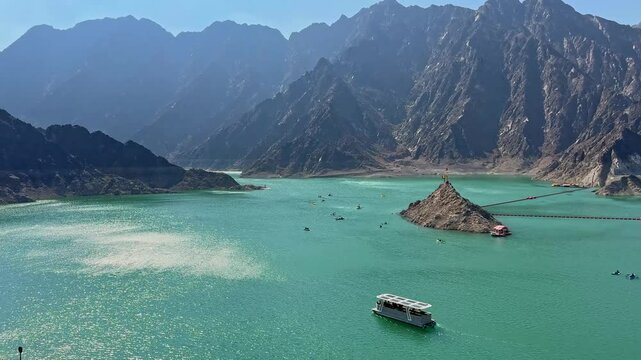 Beautiful landscape view of Hatta Dam lake and Hajar Mountains in Dubai, United Arab Emirates, showcasing serene waters surrounded by rugged mountain peaks and clear skies