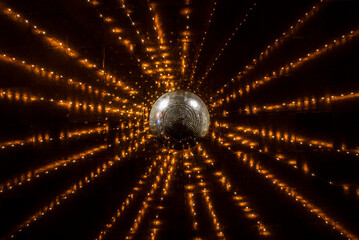 Orange string lights glowing over shiny disco ball
