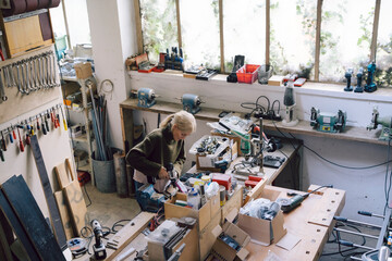 Small business owner working in a workshop with tools and equipment