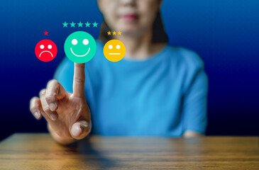 Close up woman hand show the smile face emoticon on the virtual touch screen ,give five star symbol, Customer service and business satisfaction survey.