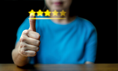 Close up woman hand thumbnail up on the virtual touch screen ,give five star symbol, Customer service and business satisfaction survey.