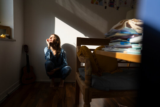 Woman enjoying sunlight in a cozy home corner