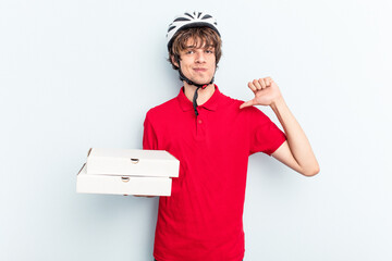 Young delivery caucasian man holding pizzas isolated on blue background feels proud and self...