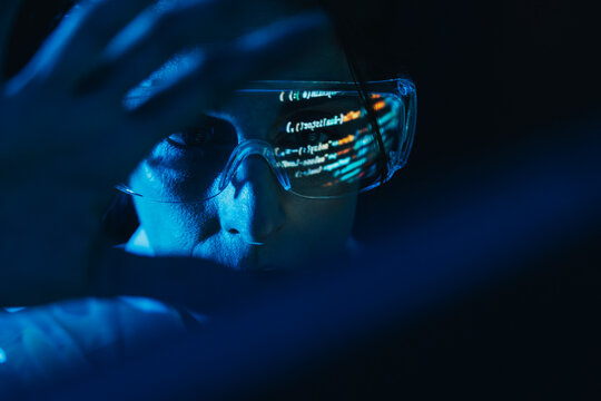 Software developer interacting with virtual code wearing glasses