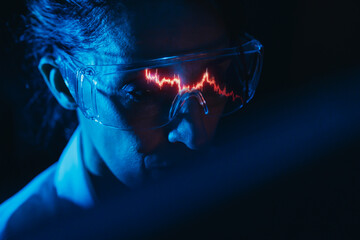 Financial analyst studying stock market candlestick chart reflection in glasses