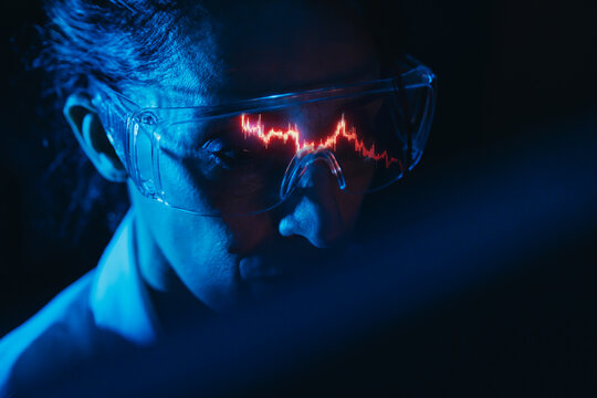 Financial analyst studying stock market candlestick chart reflection in glasses