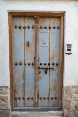 Weathered wooden door set in a traditional stone wall, showcasing the historic charm of old Bushehr’s architecture.