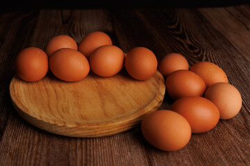 Brown eggs in wooden dish on dark wood background, illustrating the growing expenses of basic grocery items