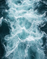 Fototapeta premium Aerial view of turquoise ocean water with white foam creating dynamic patterns and textures on a sunny day marine scene