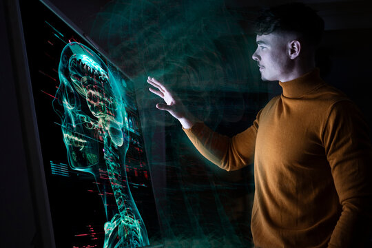 Young man interacting with augmented reality medical display
