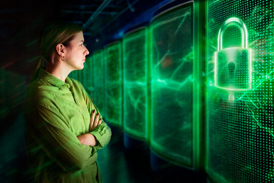 Woman in green shirt observing digital lock hologram in data center