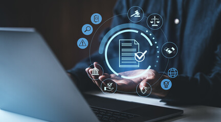 Businessman using a laptop with compliance and legal document icons floating above hands.
