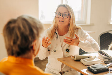 Family doctor explains treatment to patient during consultation indoors