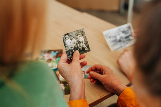 Three people at home looking at old photographs together