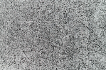 Detailed concrete surface shows cracks and texture under bright daylight, highlighting aging and...
