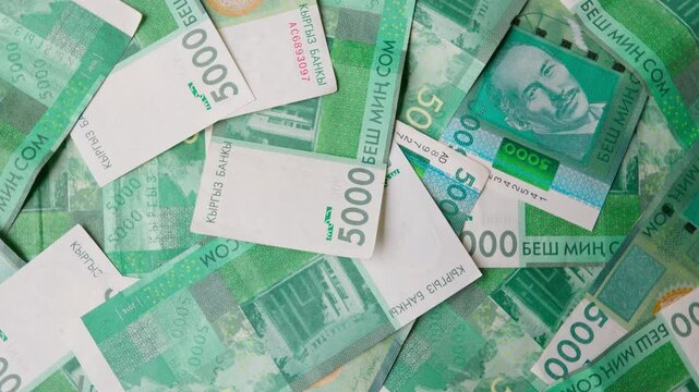 rotating background of 5000 Kyrgyzstani Som banknotes, closeup full-frame background