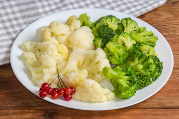 Boiled broccoli and cauliflower on dish on a rustic table