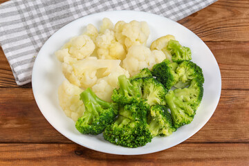 Boiled broccoli and cauliflower on dish on a rustic table