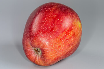 Red apple on a gray background close-up