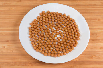 Dragee with honey and other beekeeping products on white dish