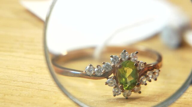 jeweler looking at ring and earrings set, jewerly inspect and verify, pawnshop concept, jewerly shop