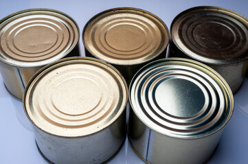 Round tin cans with food on the surface