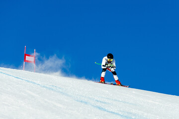skier in whirlwind of snow down snow-covered slope during competitive downhill skiing