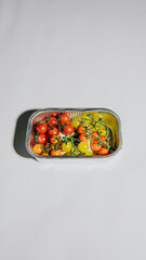 A tray of assorted fruits including tomatoes, grapes, and peppers. The tray is placed on a white background